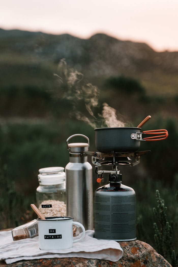 Crafting Captivating Headlines: Your awesome post title goes here A picturesque outdoor camping scene with cooking gear and steam rising from a pot at sunrise.